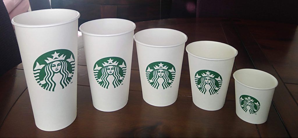 Una tazza di starbucks su un tavolo con sopra una tazza di caffè